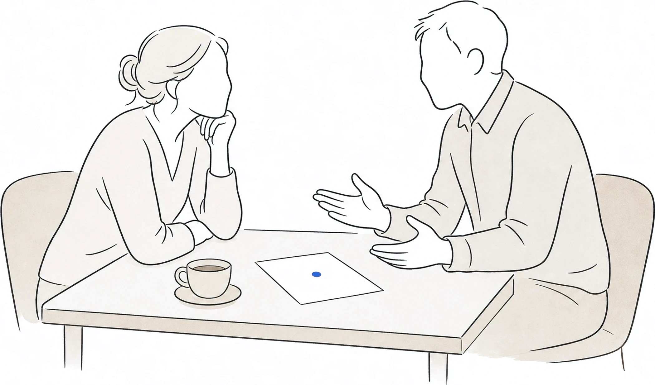 Two people in an unhurried conversation across a small desk, one listening with a cup of tea and a single sheet of paper between them.